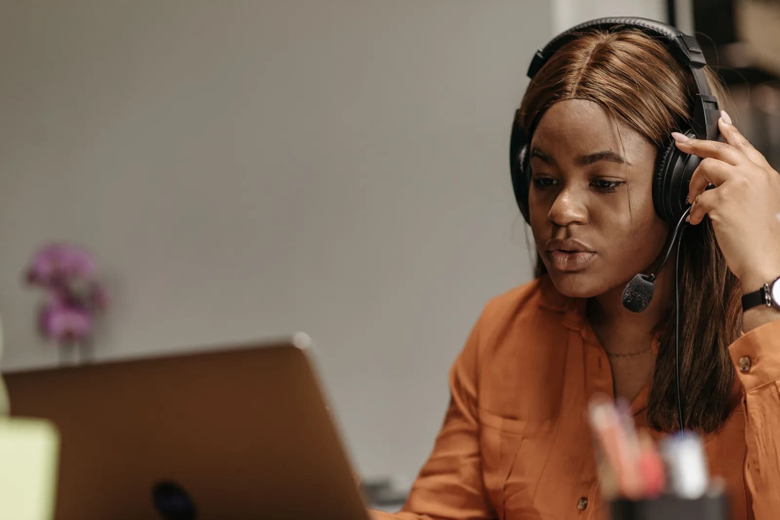 Person looking at a laptop screen with a headset on, mid-troubleshoot