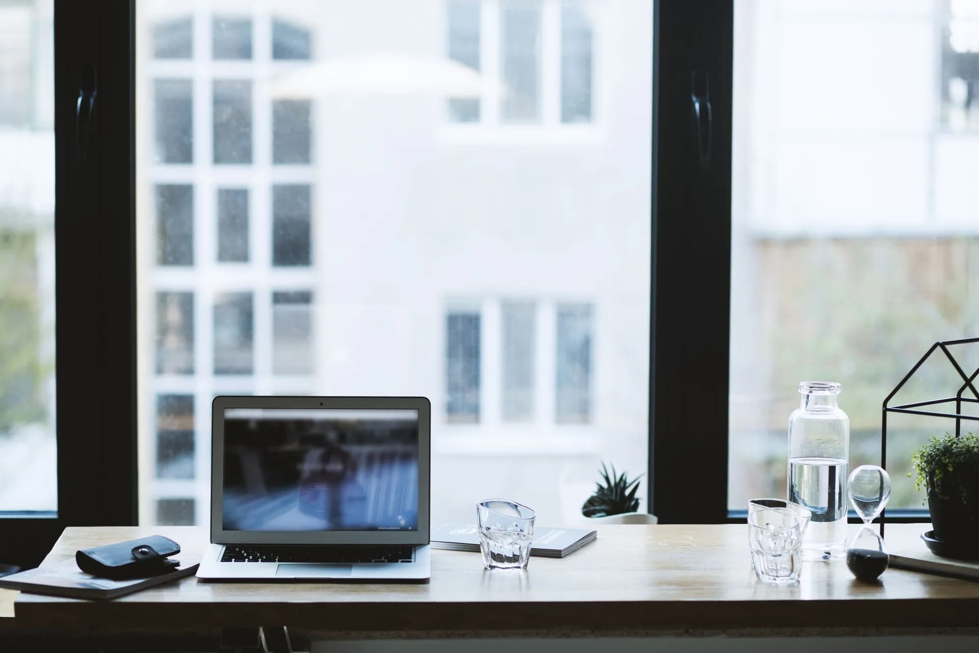 Calm desk workspace with an open laptop and a window view, framing voice dictation instead of meeting recording