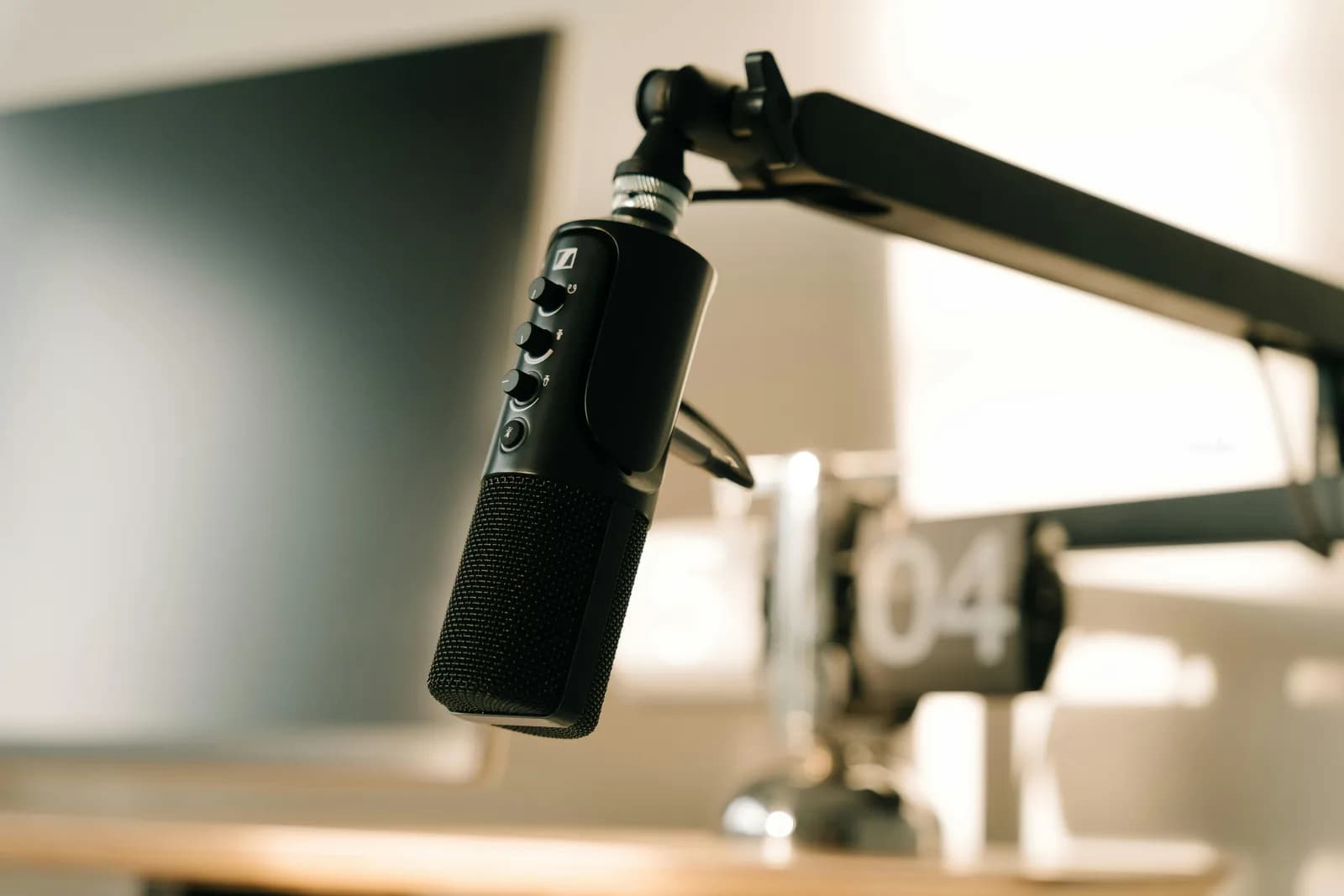 A studio microphone on a boom arm in warm light, used to check an audio input device