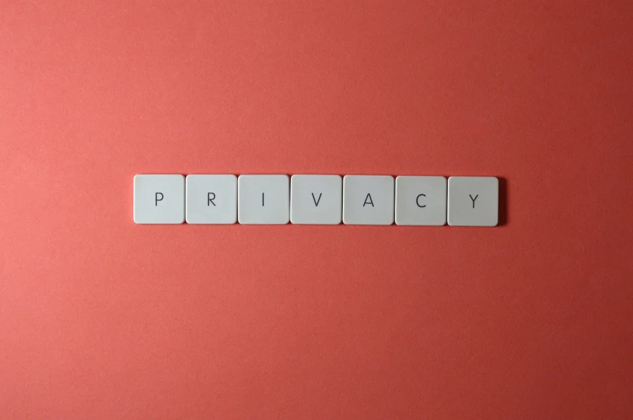 Letter tiles spelling out PRIVACY on a red background, illustrating data-handling concerns in dictation