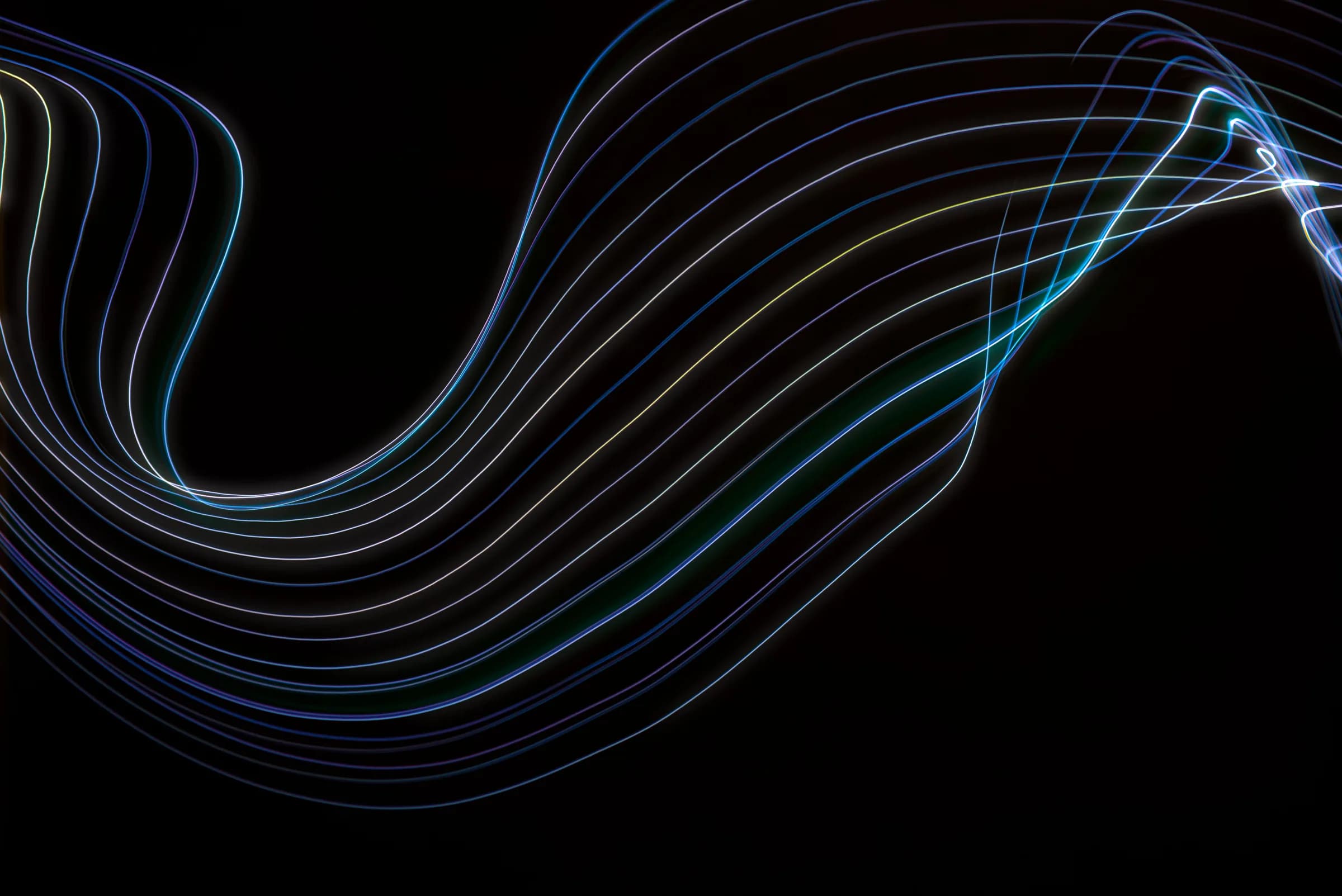 Abstract colorful light waves on a black backdrop, evoking voice signals turning into text
