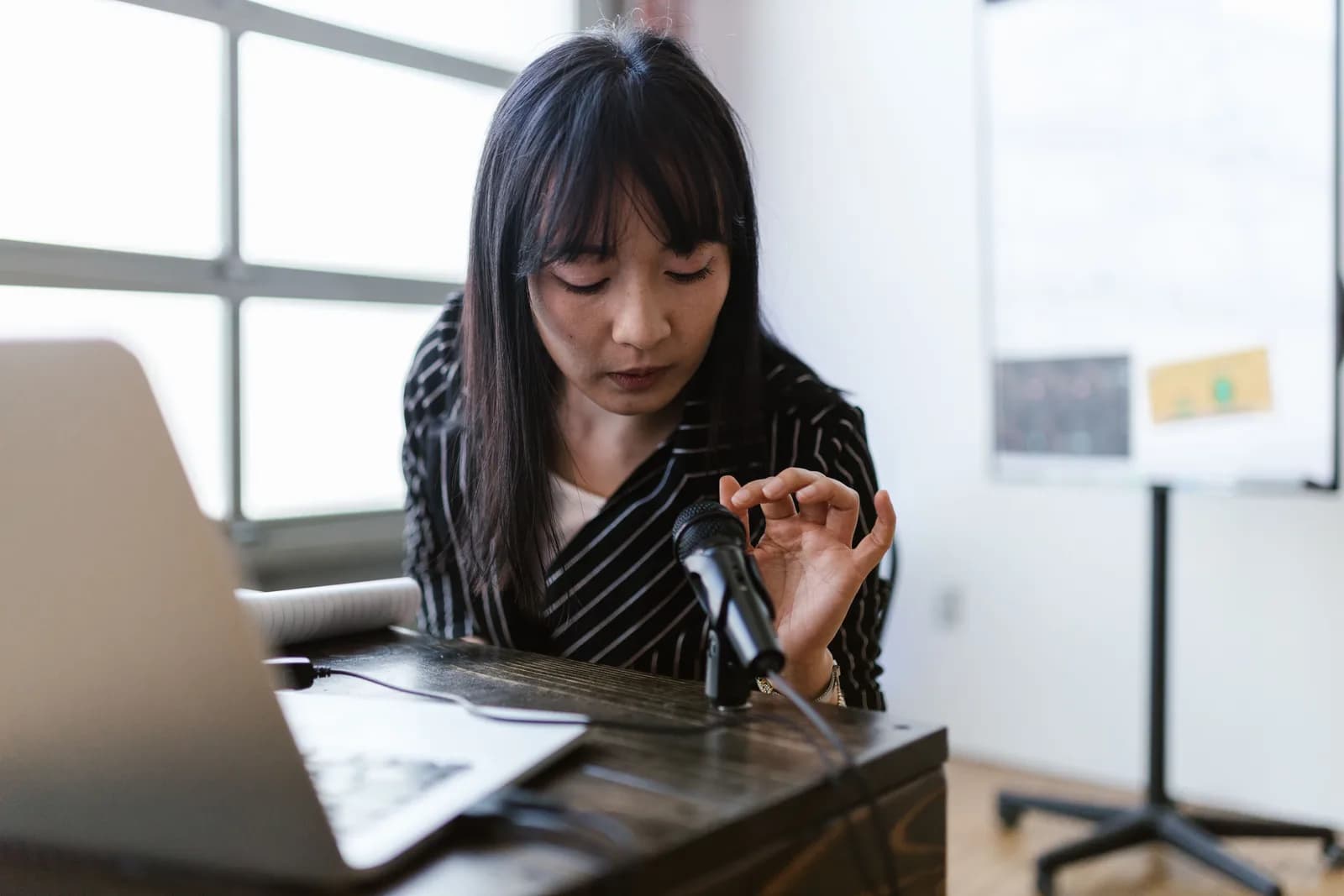 A person speaking thoughtfully at a laptop, illustrating drafting by voice rather than typing