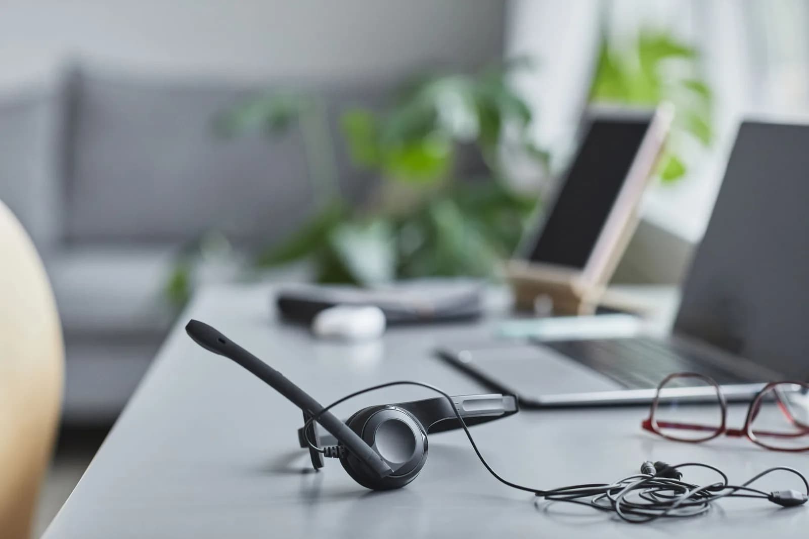 A modern desk with a headset and laptop, lit softly, evoking a Teams call workspace
